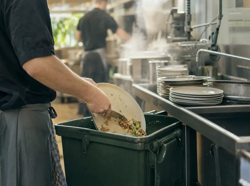 Restaurantküche: Speisereste werden in eine Tonne für Lebensmittelabfälle gegeben